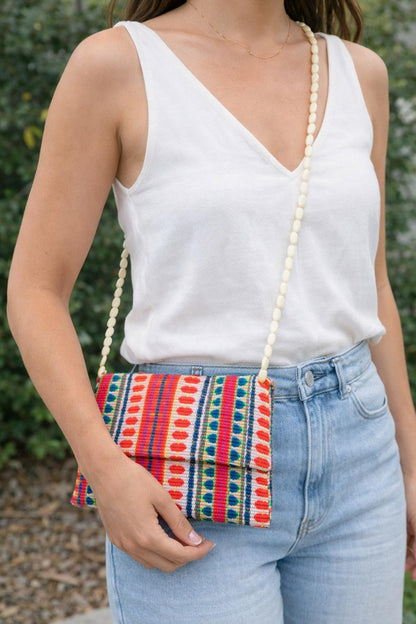 Model wearing boho clutch bag as crossbody with beaded strap for casual summer